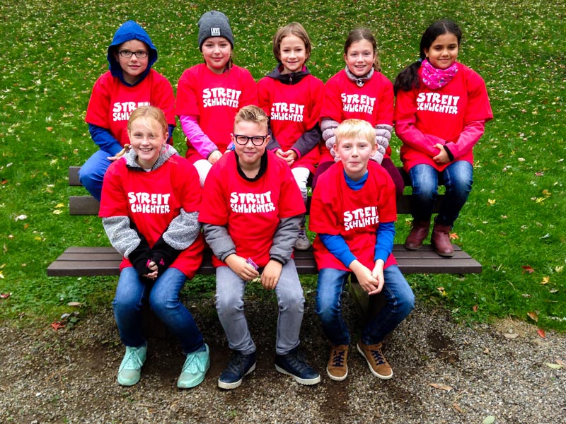 Gruppenfoto der Streitschlichter*innen in roten T-Shirts, mit der Aufschrift: Streitschlichter.