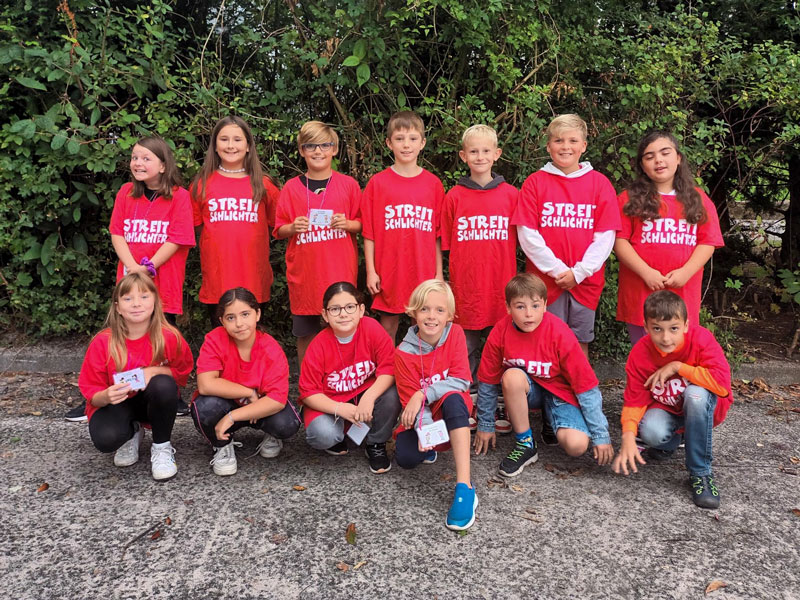 Gruppenfoto der Streitschlichter*innen in roten T-Shirts, mit der Aufschrift: Streitschlichter.