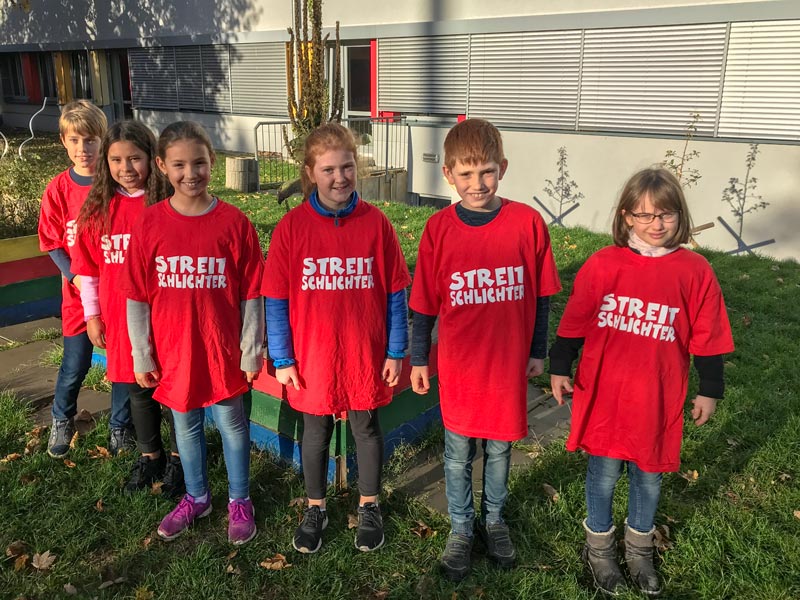 Gruppenfoto der Streitschlichter*innen in roten T-Shirts, mit der Aufschrift: Streitschlichter.