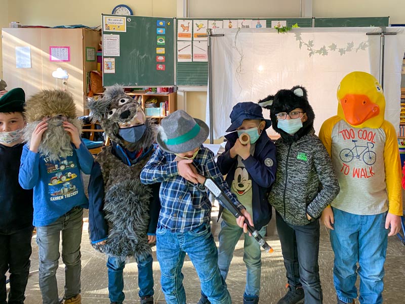 7 kostümierte Kinder im Klassenraum in einer Reihe.