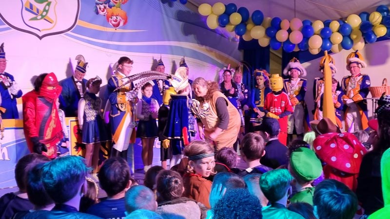 Ordensübergabe vom Kinderprinzen auf der Bühne im vollen Karnevalszelt.