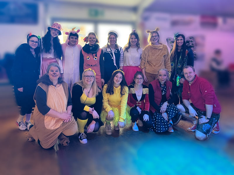 Karnevalistisches Gruppenbild des OGGS-Teams im Karnevalszelt.