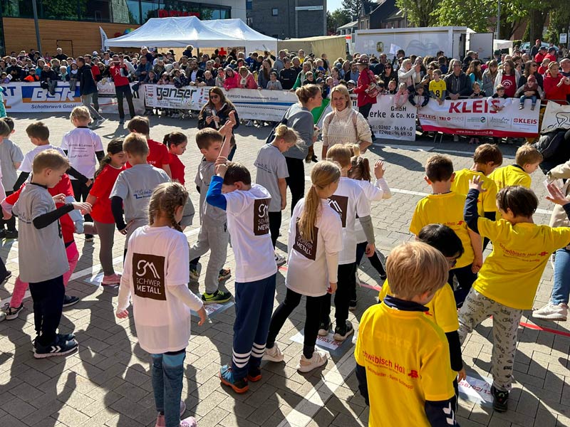 Staffeln der OGGS Mausbach vor dem Lauf vor Publikum.
