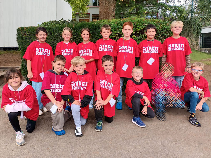 Gruppenfoto der neuen Streitschlichter*innen in roten T-Shirts, mit der Aufschrift: Streitschlichter.