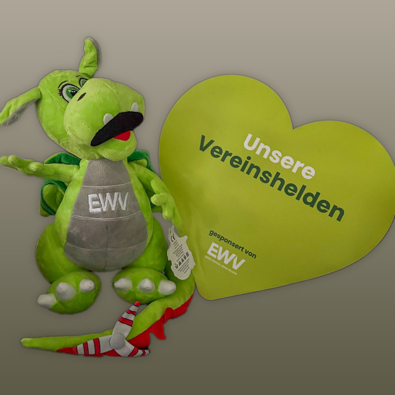 Grünes Stoffdrachenmaskottchen mit Aufschrift „EWV“ neben gelbem herzförmigem Schild mit Text „Unsere Vereinshelden gesponsert von EWV“.