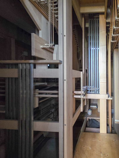 Innenansicht einer Kirchenorgel mit vertikalen und horizontalen Balken sowie Metallstreben.