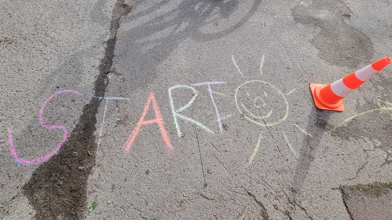 Bunte Kreideschrift auf dem Asphalt mit dem Wort START.